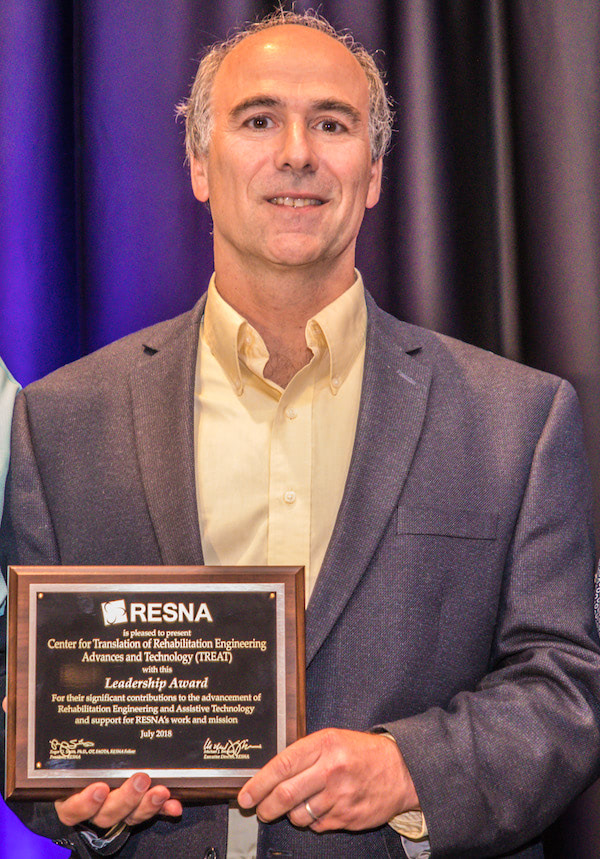Rick Greenwald holding the RESNA award